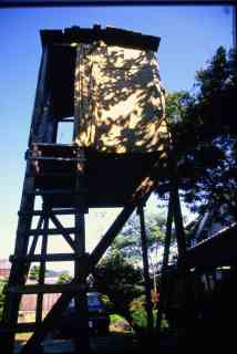 *Hochsitz*, 1999, 180 x 180 x 500 cm, telegraph poles, boards, old fabrics, wallpaper